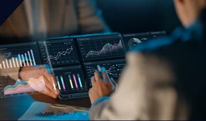 Analyst reviewing charts on a laptop and tablet